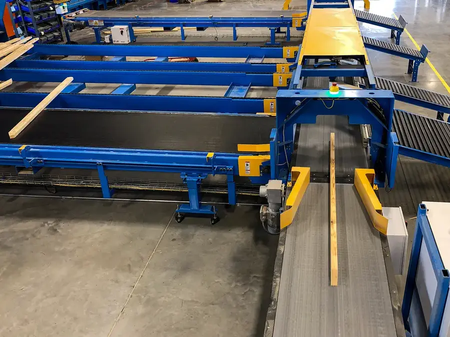 Automated lumber conveyor and saw infeed system in a truss plant