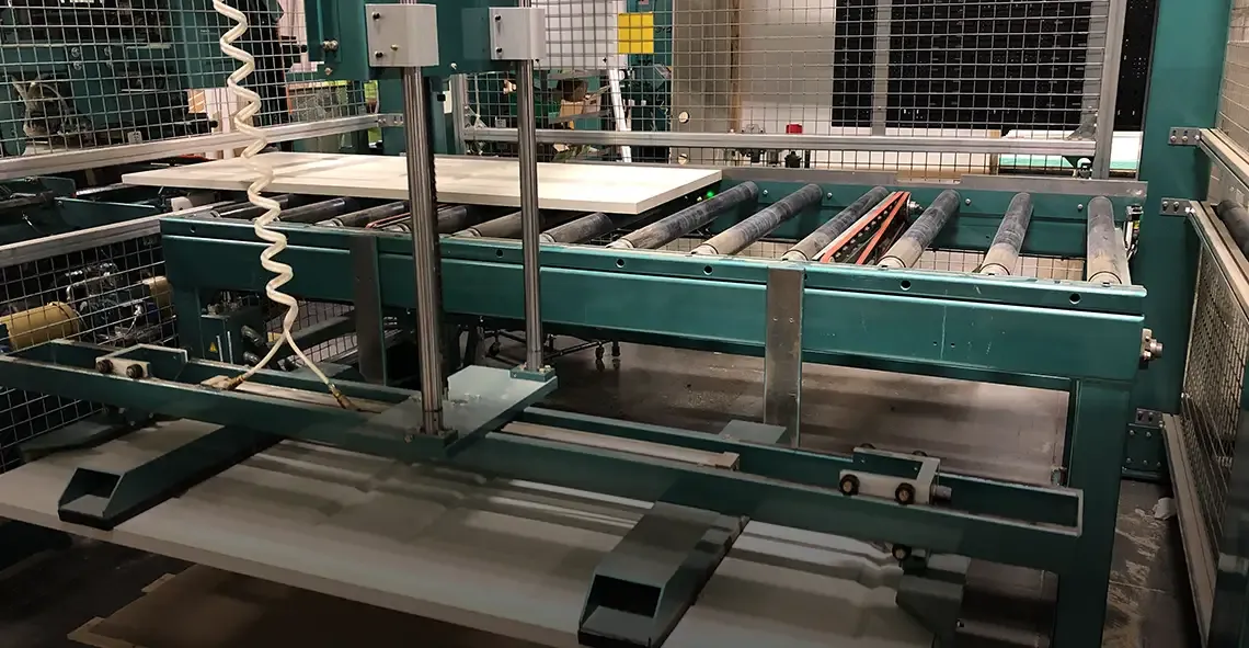 Door machining equipment with roller conveyor feeding a door slab
