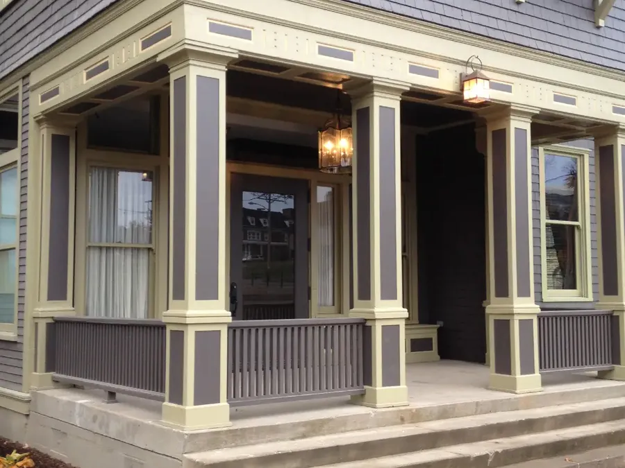 Two-tone painted porch with paneled square columns, railings, and dentil trim