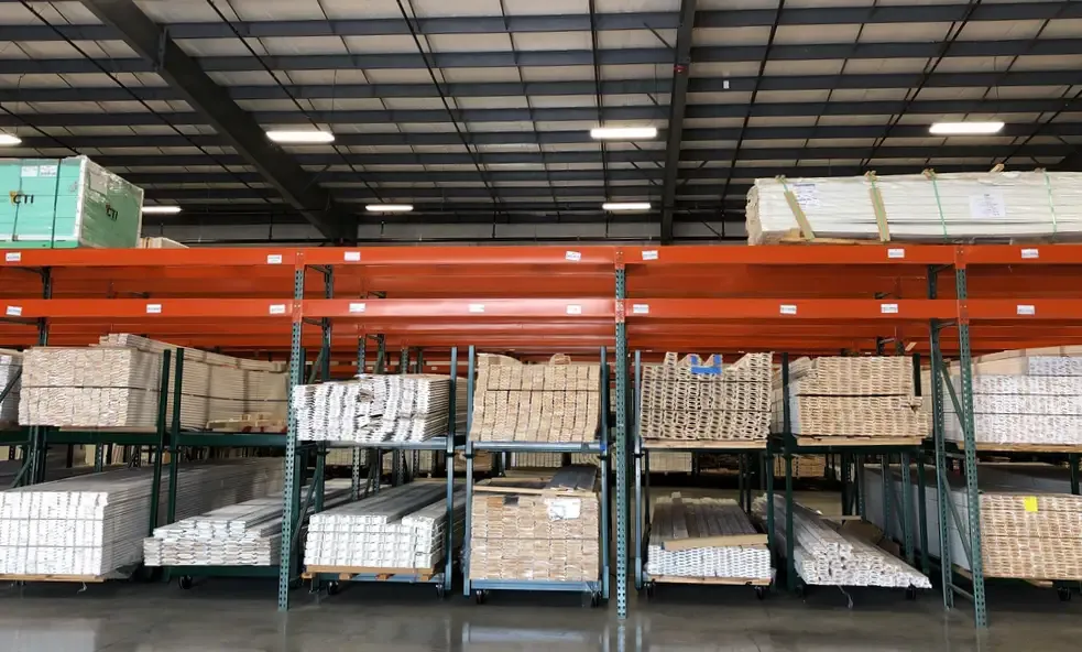 Warehouse pallet racks loaded with bundled white moulding and trim