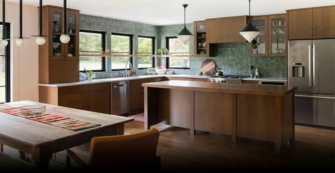 Kitchen with wood cabinets, green tile backsplash, island and globe pendant lights