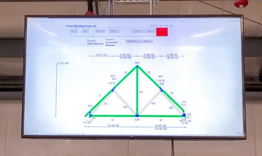 Wall-mounted screen showing a roof truss layout with member labels and dimensions