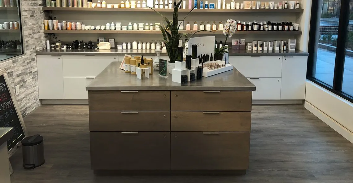 Retail display island and shelving with wood-grain drawers in a skincare shop