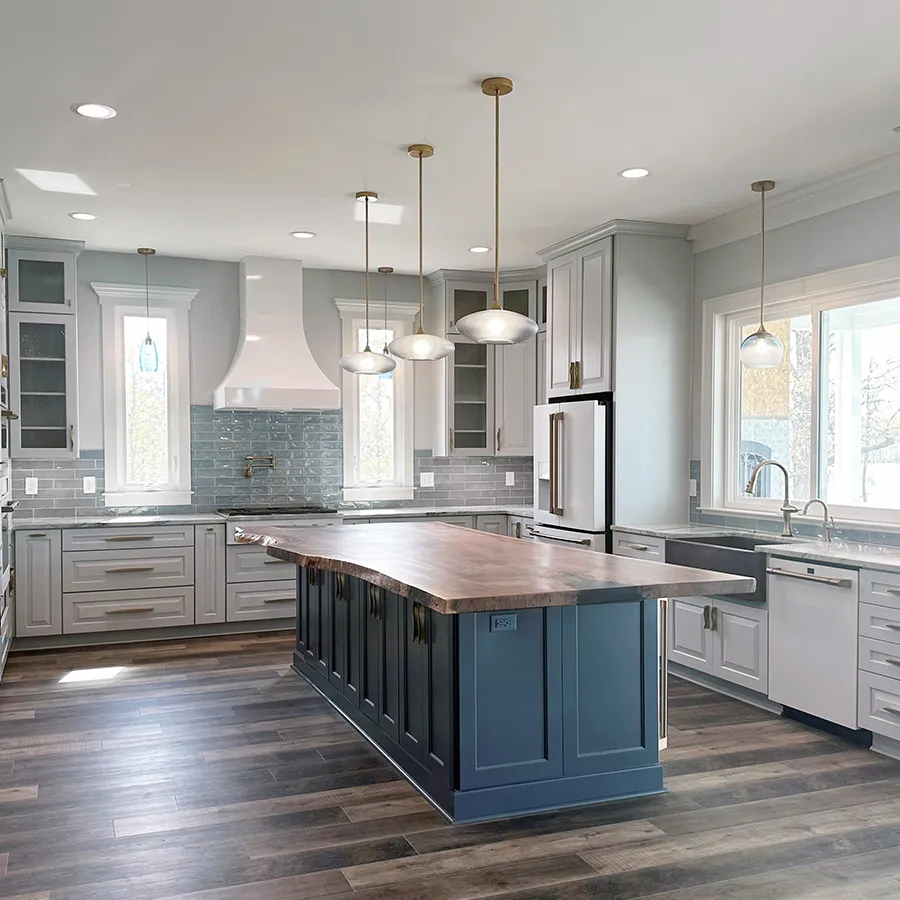 Gray kitchen with blue island, live-edge wood countertop and glass tile backsplash